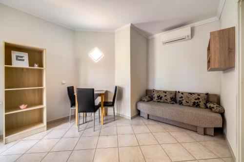 a living room with a table and a couch at Helka Apartmanház in Balatonlelle