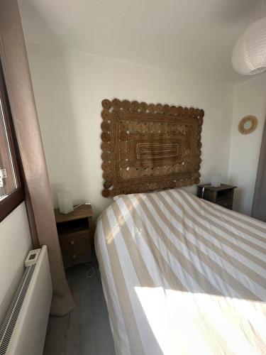 une chambre avec un lit avec une tête de lit en bois dans l'établissement Le Balbec - Appartement Cosy, à Cabourg