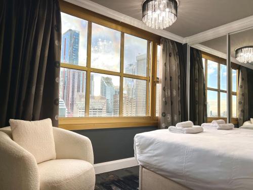 a hotel room with a bed and a chair and a window at Stylish Family 1BR with Cozy Bunks and Games for 5 in Sydney