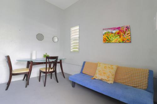 Una sala de estar con un sofá azul y una mesa. en Explore Puerto Rico, en San Juan