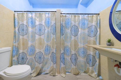 Un baño con inodoro y cortina de ducha. en Explore Puerto Rico, en San Juan