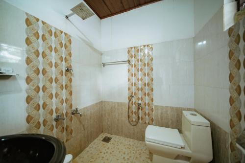 a bathroom with a toilet and a shower at Munroe Island Lake Resort in Kollam
