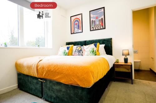 a bedroom with a large bed with an orange blanket at 2 Bedroom Apartment By Littlepiggyrentals Short Lets & Serviced Accommodation Stevenage With Free Parking, Gym & Roof Garden in Stevenage