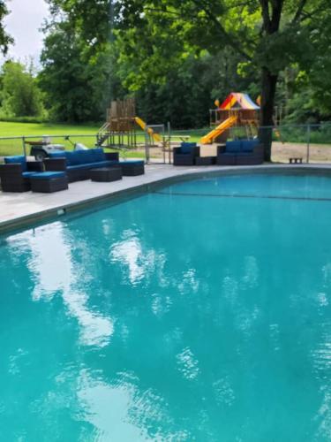 a blue swimming pool with a playground in the background at Cabin 12 in Deer River