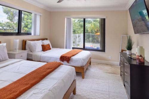two beds in a room with two windows at 4-min Walk to Beach Pool Tiki Canal Boat Dock in Deerfield Beach