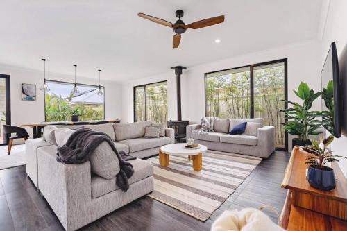 a living room with two couches and a ceiling fan at Mainbreak Dunsborough Stylish Coastal Retreat in Dunsborough