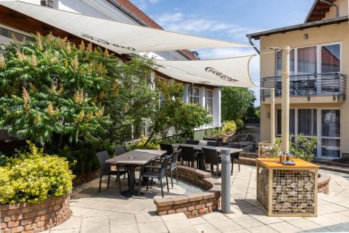 a patio with a table and chairs and an umbrella at CE Plaza Hotel in Siófok