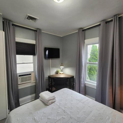 South HackensackにあるPrivate Bedroom In Shared Apt Cのベッドルーム1室(ベッド1台、窓2つ、テーブル付)