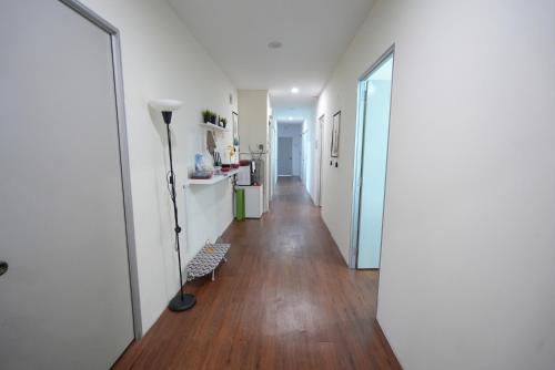 a hallway with white walls and a hard wood floor at Aimelia guest house in Petaling Jaya