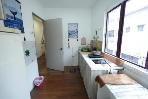 a kitchen with white counters and a window and a sink at Aimelia guest house in Petaling Jaya