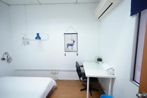 a room with a bed and a desk with a phone at Aimelia guest house in Petaling Jaya