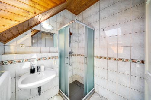 a bathroom with a sink and a shower at Helka Apartmanház in Balatonlelle