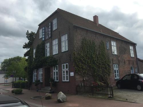 a brick building with ivy on the side of it at Hotel Packhaus in Hooksiel