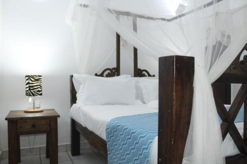a bedroom with a bed with a canopy at Blessing Holiday Homes - Diani Beach in Diani Beach