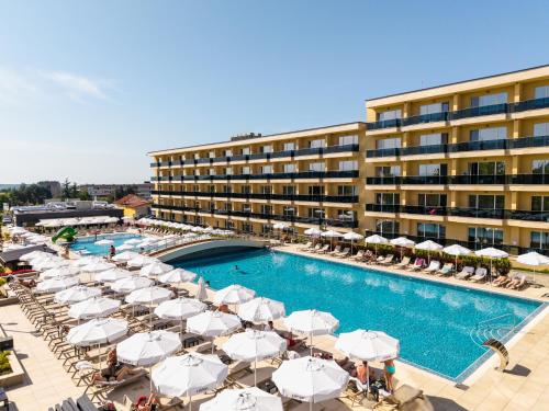a pool with umbrellas and chairs and a hotel at Empire Balneo & Spa Hotel in Hisarya