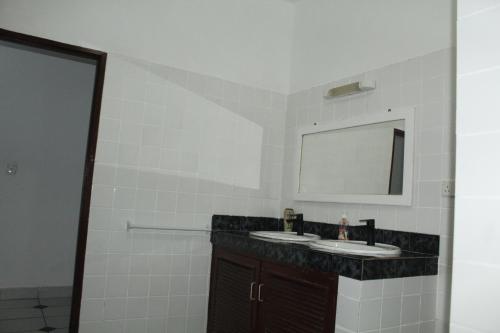 a bathroom with two sinks and a mirror at Blessing Holiday Homes - Diani Beach in Diani Beach