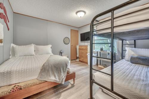 a bedroom with two bunk beds and a tv at The Lakeside Shack on West Lake Okoboji in Spirit Lake