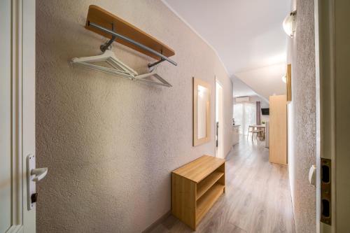 a hallway of a house with a wooden bench on the wall at Helka Apartmanház in Balatonlelle