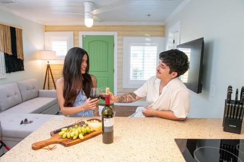 a man and woman sitting at a table with a bottle of wine at King Bed-Step to Madeira Beach-Heated Pool-Private in St Pete Beach