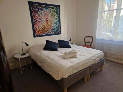 une chambre avec un lit avec un tableau sur le mur dans l'établissement Orangerie - Appartement 2 chambres et jardin partagé, à Strasbourg
