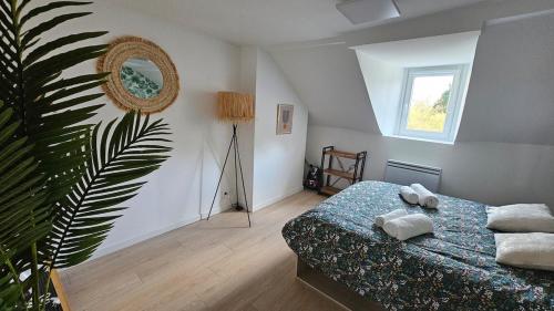 - une chambre avec un lit et une plante dans l'établissement Le Naturel, à Montargis