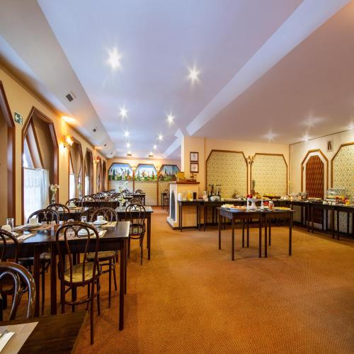 a restaurant with tables and chairs in a room at Hotel Chateau in Campos do Jordão