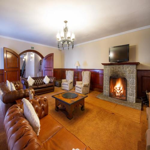 a living room with a couch and a fireplace at Hotel Chateau in Campos do Jordão