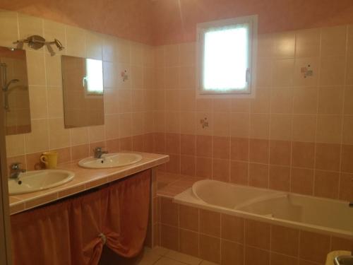 La salle de bains est pourvue de 2 lavabos, d'une baignoire et d'une fenêtre. dans l'établissement Maison Neuve à Longeville-sur-Mer : Confort et Tranquillité Proche Plage - FR-1-336-117, à Longeville-sur-Mer