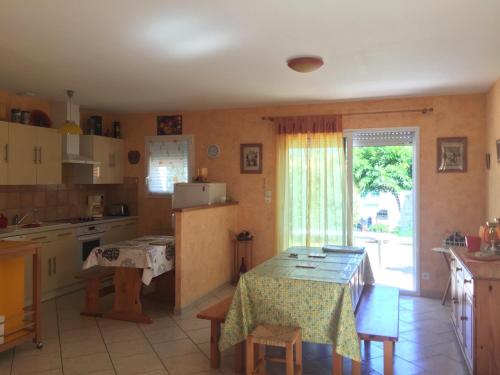 une cuisine avec une table et une table et une fenêtre dans l'établissement Maison Neuve à Longeville-sur-Mer : Confort et Tranquillité Proche Plage - FR-1-336-117, à Longeville-sur-Mer