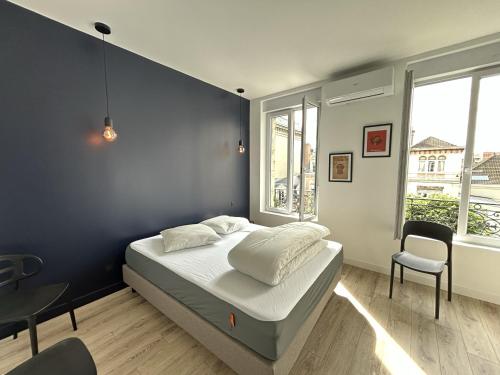 une chambre avec un lit et un mur bleu dans l'établissement Rêves et bulles, à Reims