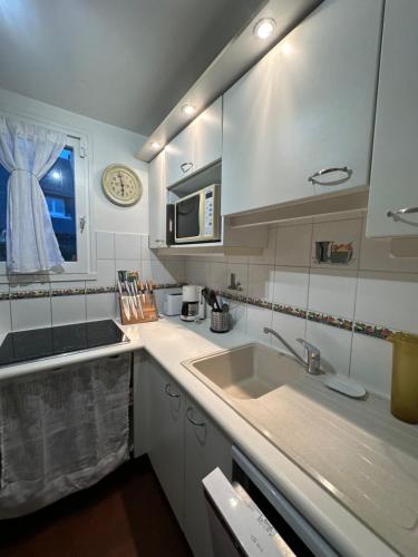 une cuisine avec un évier et un micro-ondes dans l'établissement Cottage with Garden 5mn Beach, à Cabourg