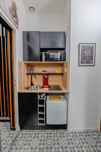 une petite cuisine avec un évier et un micro-ondes dans l'établissement 50 Nuances Nirvana - Love Room à Rouen, à Rouen