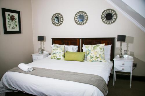 a bedroom with a large white bed with pillows at Rawdons Hotel & Brewery in Nottingham Road
