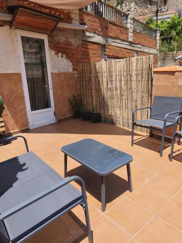 two blue chairs and a table on a patio at Los picarzos apartamento in Ayna