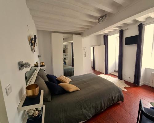 une chambre avec un grand lit dans une pièce dans l'établissement La Signature - Appt 70m² pour 6 voyageurs, à Bayeux