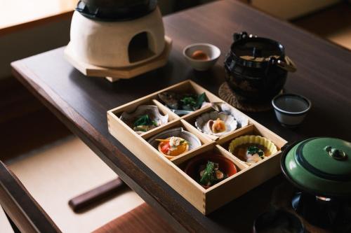 un tavolo di legno con sopra una scatola di sushi di Toemon-湯右衛門- a Kyotango