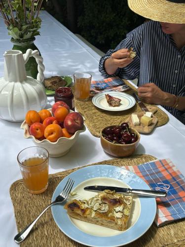 a table with a plate of food and a bowl of fruit at Le Clos de Gordes in Gordes