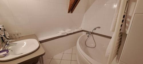 a bathroom with a sink and a tub and a toilet at Auberge Côté Rivière in Is-sur-Tille
