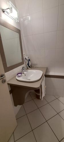 a bathroom with a sink and a mirror at Auberge Côté Rivière in Is-sur-Tille