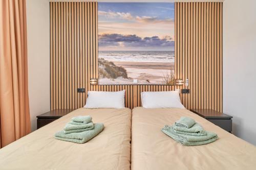 Un dormitorio con dos camas con toallas encima. en Breathtaking Penthouse Las Azaleas, en Torrox