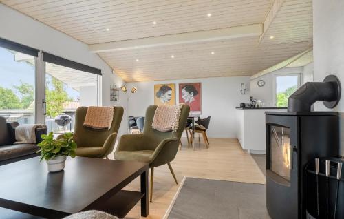 a living room with a fireplace and a table and chairs at 3 Bedroom Stunning Home In Hejls in Hejls