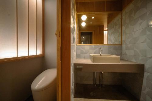 un bagno con lavandino, water e specchio di Toemon-湯右衛門- a Kyotango