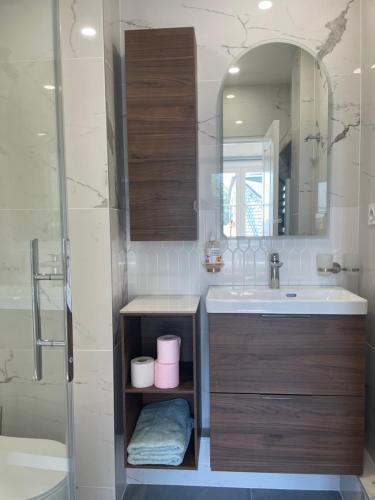 une salle de bain avec un lavabo et un miroir dans l'établissement Le nid de la cathédrale, à Bayeux