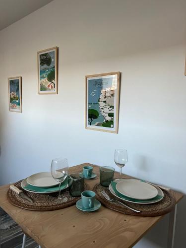 une table en bois avec des assiettes et des verres à vin dessus dans l'établissement La Suite Corse avec Spa, à Lavilletertre