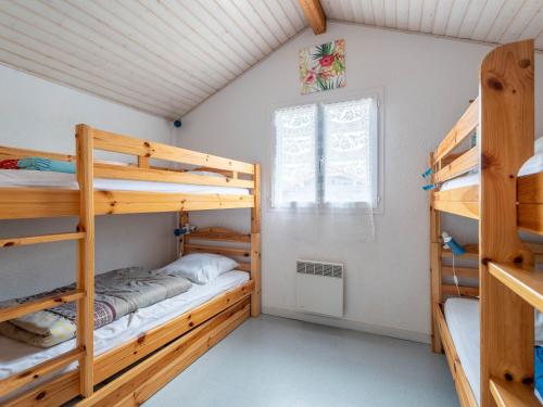 une chambre avec deux lits superposés et une fenêtre dans l'établissement Maisonnette 2 étoiles à Mimizan Plage à 200m de l'océan, 6 pers, terrasse, parking, tout confort - FR-1-50-75, à Mimizan
