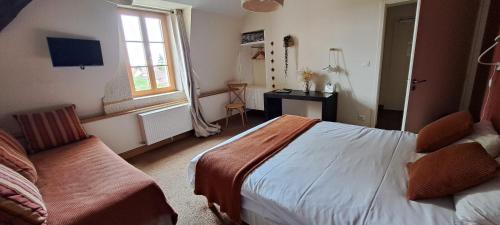 a bedroom with a bed and a desk and a window at Auberge Côté Rivière in Is-sur-Tille