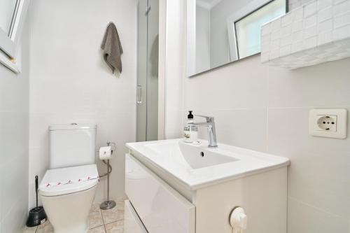 Un baño blanco con lavabo e inodoro. en Sea View Capistrano Nerja, en Nerja