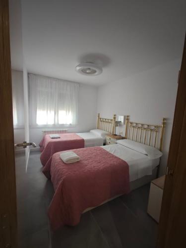 a bedroom with two beds with red sheets at Apartaments IXA in Manresa