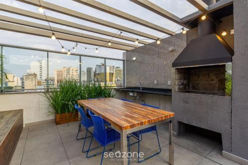 a kitchen with a wooden table and blue chairs at TCO - Apartamentos no Centro Histórico Porto Alegre/RS in Porto Alegre