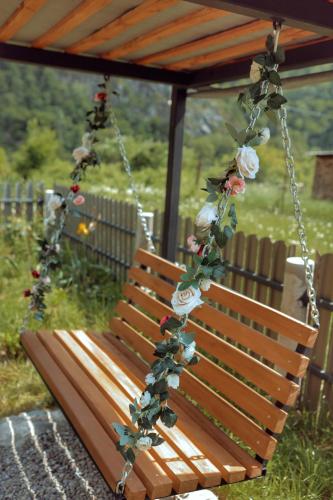 a swing with flowers on it in a garden at Woodlandia Resort Borjomi in Borjomi